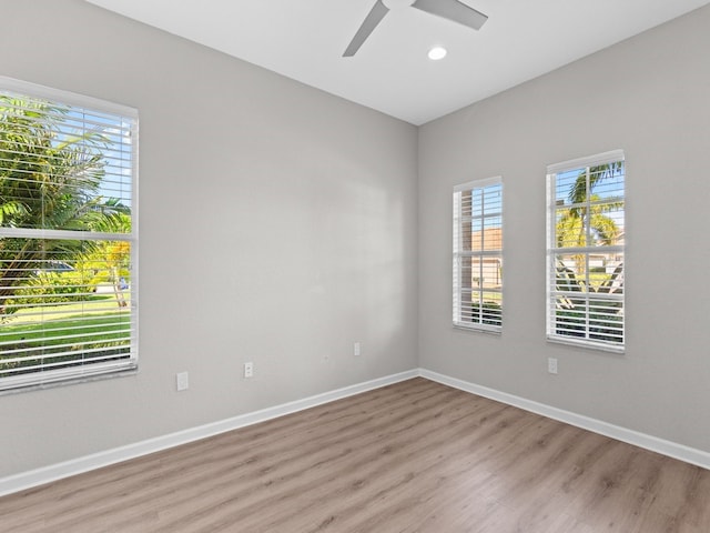 empty room with light hardwood / wood-style floors, ceiling fan, and plenty of natural light