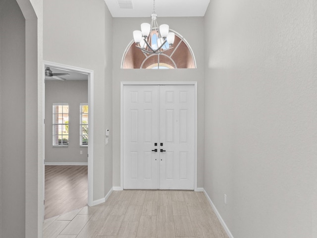 entrance foyer featuring light hardwood / wood-style floors and ceiling fan with notable chandelier