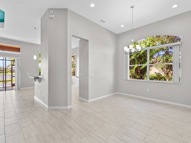 spare room with light hardwood / wood-style floors and a chandelier