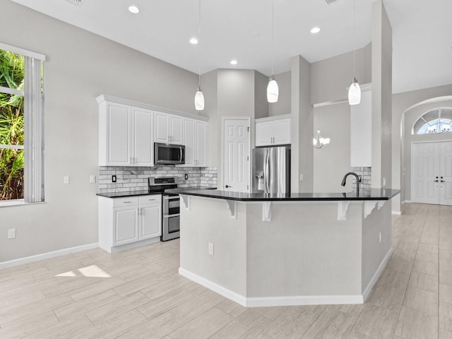 1745 Belmont Cir SW, Vero Beach, FL 32968 - kitchen featuring appliances with stainless steel finishes, a kitchen bar, plenty of natural light, and a high ceiling