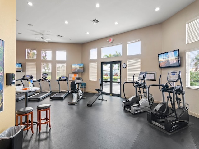 workout area with ceiling fan and a high ceiling