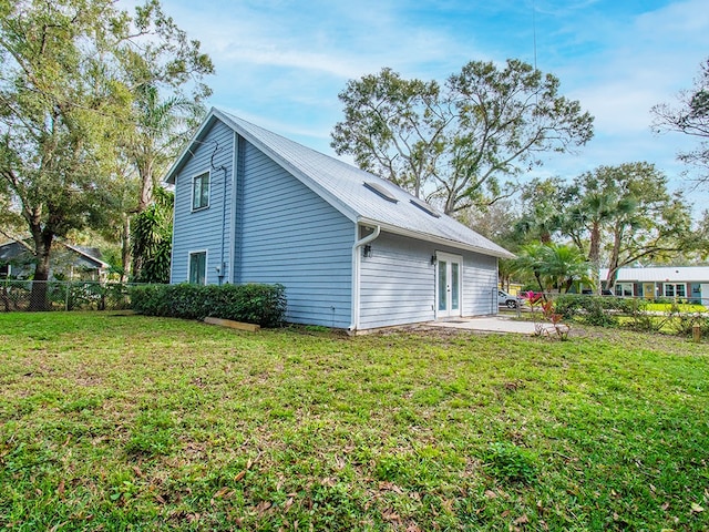 view of side of home with a yard and a patio