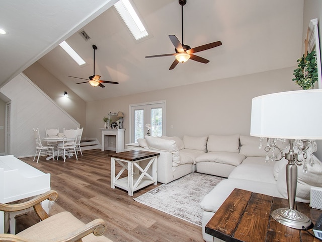 living room with hardwood / wood-style floors, french doors, ceiling fan, and lofted ceiling