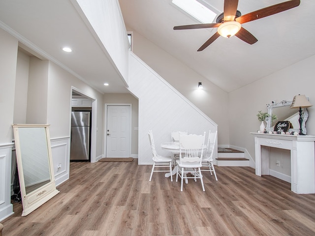 unfurnished dining area featuring ceiling fan, lofted ceiling, ornamental molding, and light hardwood / wood-style flooring