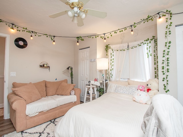 bedroom with a closet, hardwood / wood-style flooring, and ceiling fan