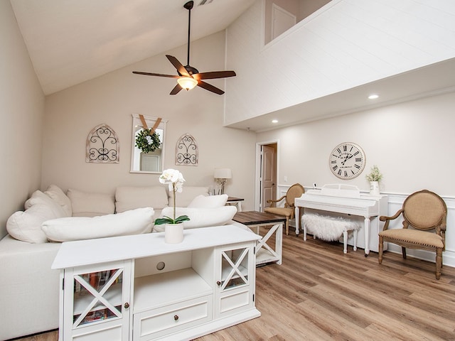 living room with wood-type flooring, high vaulted ceiling, and ceiling fan