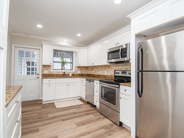 kitchen with stone counters, white cabinetry, sink, crown molding, and appliances with stainless steel finishes