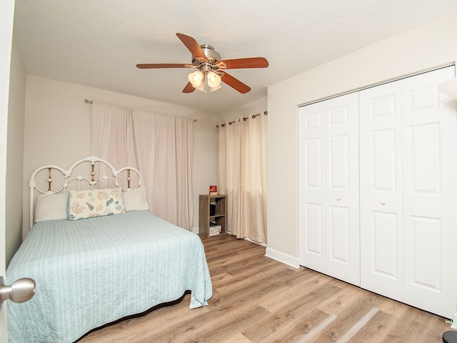 bedroom with ceiling fan, wood-type flooring, and a closet