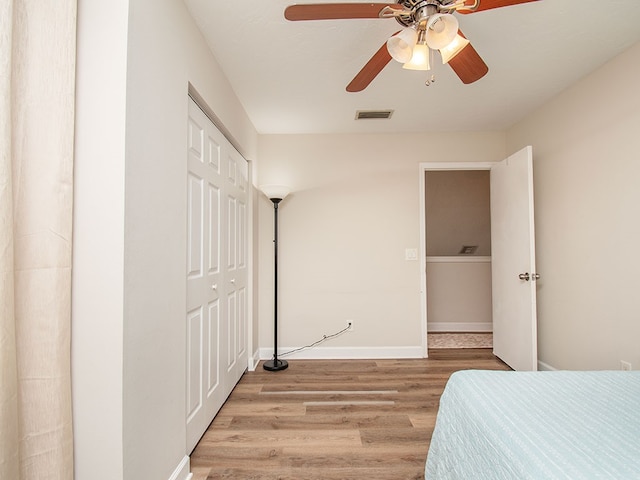 unfurnished bedroom featuring ceiling fan, light hardwood / wood-style flooring, and a closet