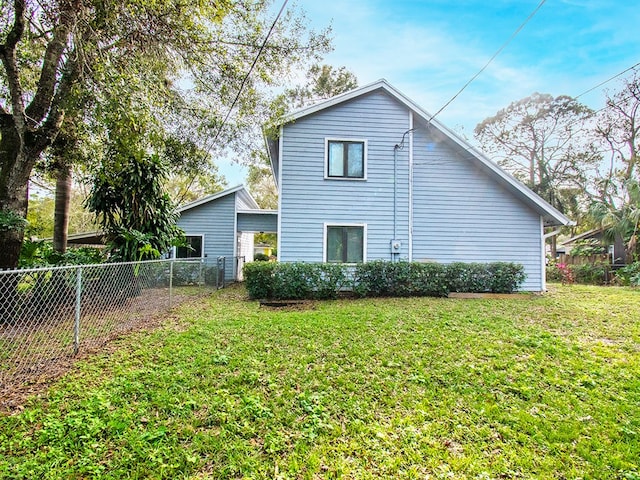 rear view of property featuring a lawn