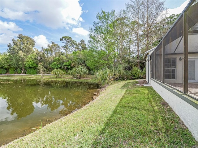 view of yard with glass enclosure and a water view