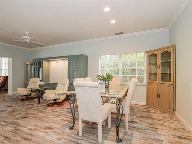 dining space with ornamental molding, light wood finished floors, visible vents, and baseboards