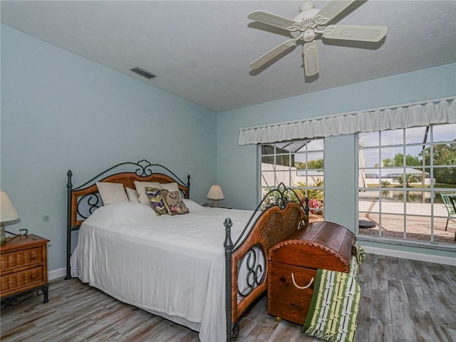 bedroom with visible vents, ceiling fan, baseboards, and wood finished floors