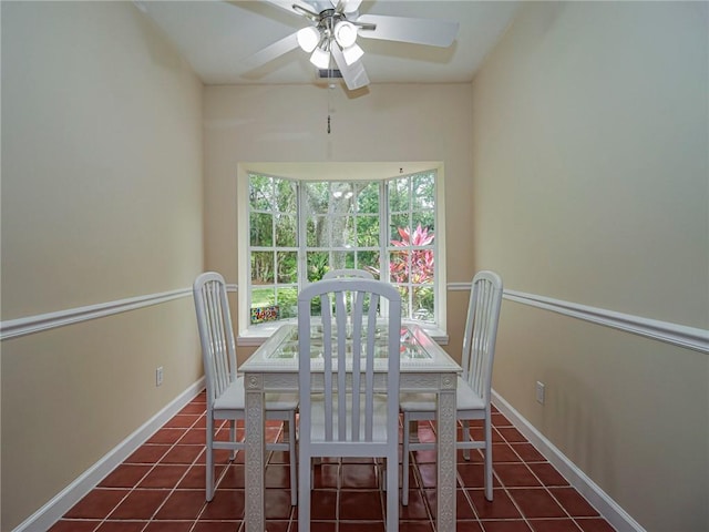 unfurnished dining area with ceiling fan, tile patterned flooring, and baseboards