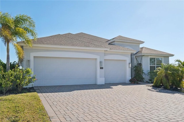 view of front of property with a garage, decorative driveway, and stucco siding