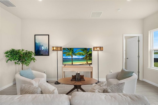 living room featuring a wealth of natural light, visible vents, and baseboards