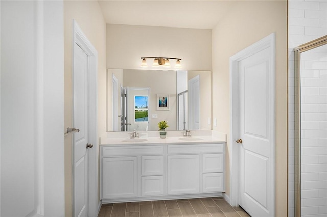 full bath with double vanity, tiled shower, and a sink