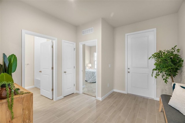 entryway with light wood-type flooring, baseboards, and visible vents