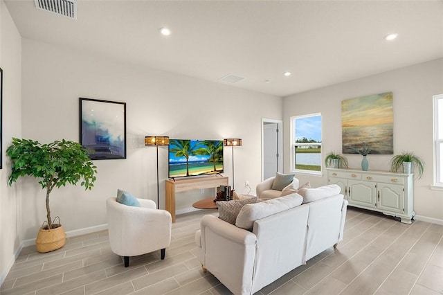 living room featuring baseboards, wood tiled floor, visible vents, and recessed lighting