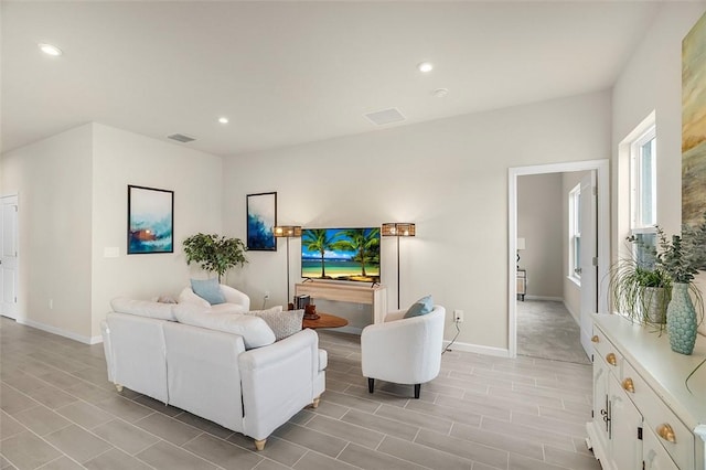 living room with baseboards, visible vents, and recessed lighting