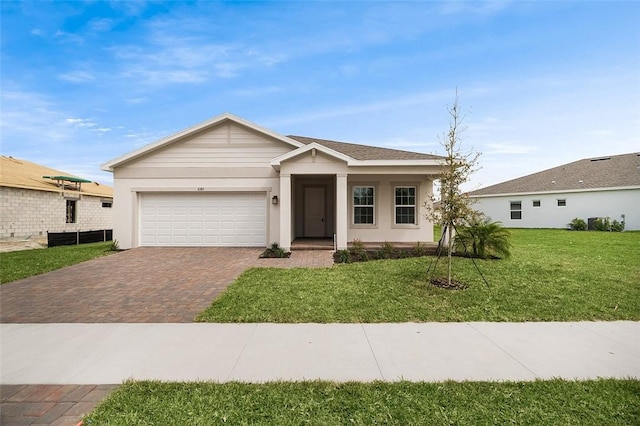 ranch-style home with a garage, decorative driveway, a front yard, and stucco siding