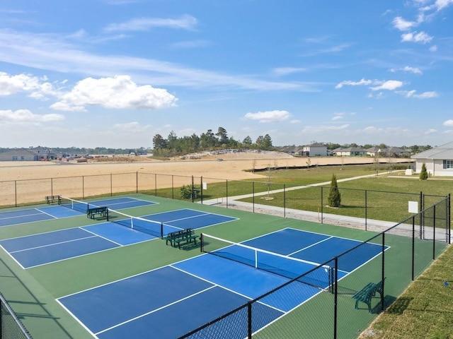 view of tennis court featuring community basketball court and fence