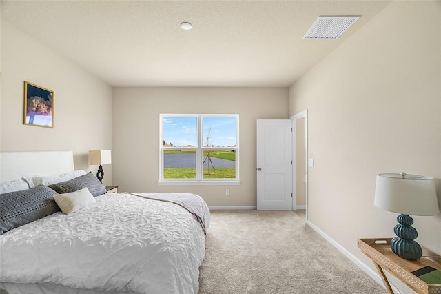 bedroom with visible vents, light carpet, and baseboards