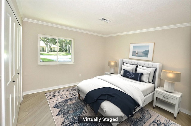 bedroom featuring a closet, ornamental molding, a textured ceiling, and light hardwood / wood-style flooring