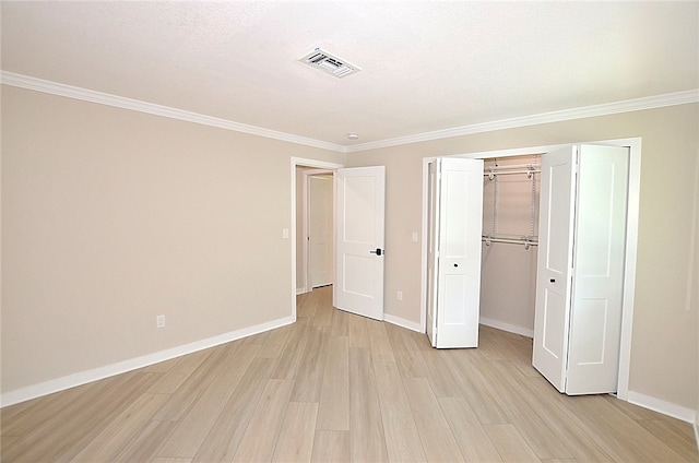 unfurnished bedroom featuring a closet, ornamental molding, a textured ceiling, and light wood-type flooring