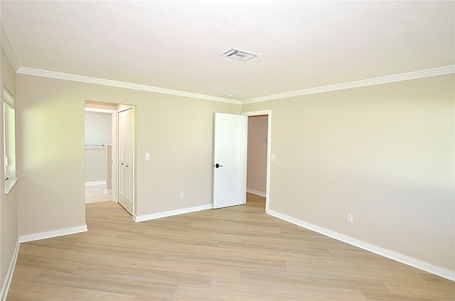 unfurnished bedroom featuring light hardwood / wood-style floors, ornamental molding, a textured ceiling, and a closet