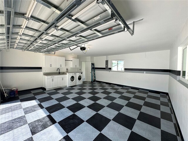 garage featuring independent washer and dryer, electric panel, a garage door opener, and sink