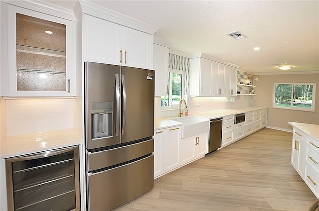 kitchen featuring wine cooler, plenty of natural light, white cabinets, and appliances with stainless steel finishes