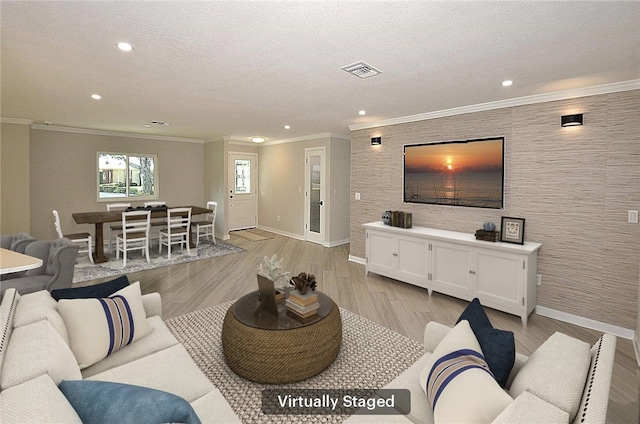 living room with light hardwood / wood-style flooring, a textured ceiling, and ornamental molding