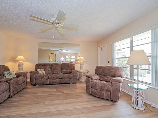 living room with light wood-style floors, a textured ceiling, and ceiling fan
