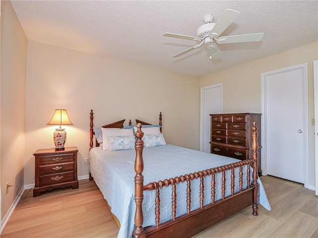 bedroom with wood finished floors, a ceiling fan, and a textured ceiling