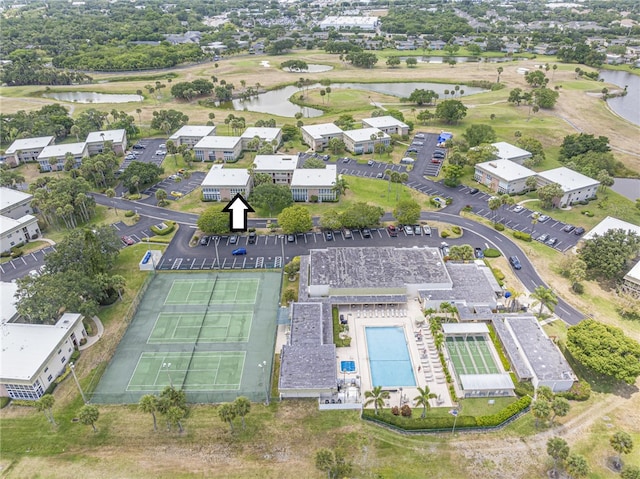 drone / aerial view of a nearby body of water and a pool area