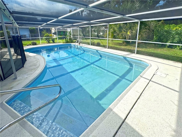 view of pool with a patio, glass enclosure, and a lawn