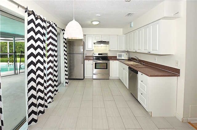 kitchen featuring hanging light fixtures, white cabinetry, and appliances with stainless steel finishes