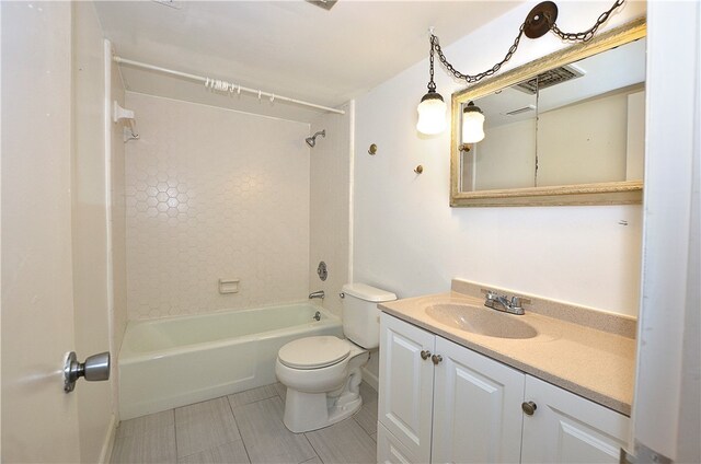 full bathroom featuring tiled shower / bath, vanity, and toilet