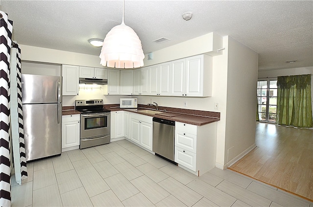 kitchen featuring light hardwood / wood-style floors, white cabinets, a textured ceiling, sink, and appliances with stainless steel finishes