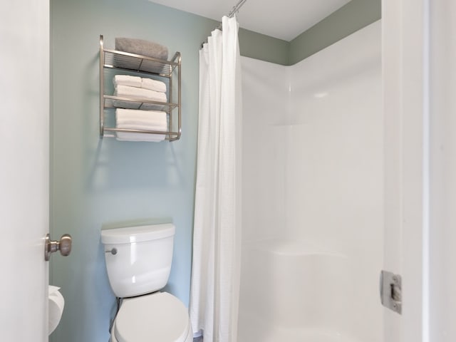 bathroom with toilet and a shower with curtain