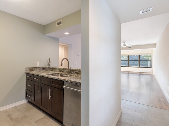 kitchen featuring sink, light stone counters, dark brown cabinets, light wood-type flooring, and dishwasher