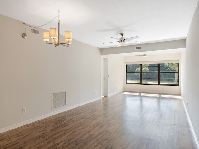 empty room with hardwood / wood-style flooring and ceiling fan with notable chandelier