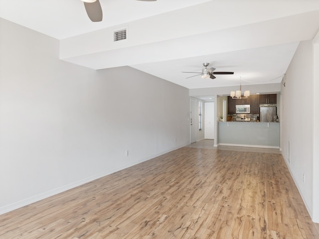 unfurnished living room with ceiling fan with notable chandelier and light hardwood / wood-style flooring