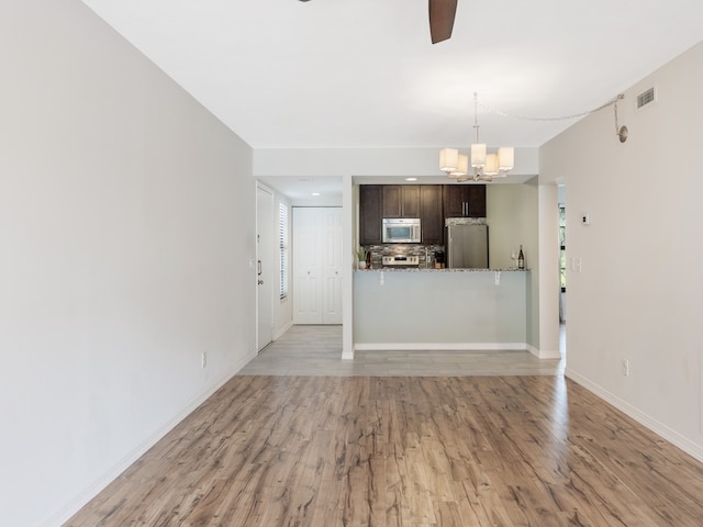 unfurnished living room featuring light hardwood / wood-style floors and a chandelier