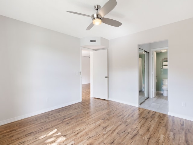 unfurnished bedroom with light hardwood / wood-style floors, ceiling fan, and connected bathroom