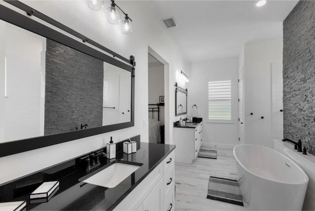 bathroom with a tub to relax in and vanity