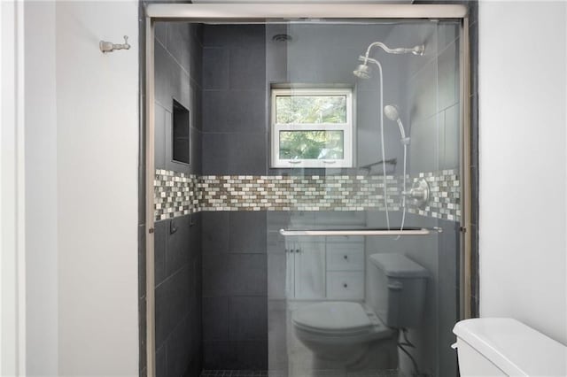 bathroom featuring toilet and an enclosed shower