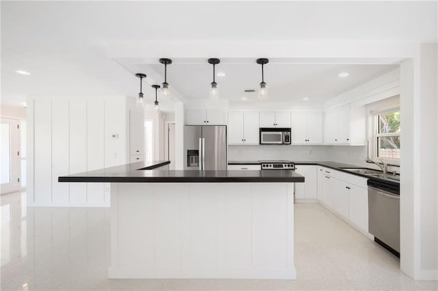 kitchen with white cabinets, a center island, hanging light fixtures, and stainless steel appliances