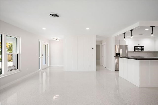 kitchen with white cabinets, decorative light fixtures, appliances with stainless steel finishes, and tasteful backsplash